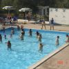 Piscina con persone che nuotano e ombrelloni.