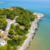 Case bianche tra alberi vicino al mare.
