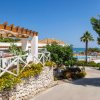 Struttura con pergolato, giardino fiorito e vista sulla piscina e sul mare.