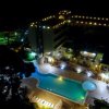 Piscina illuminata di notte accanto a un hotel.