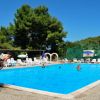 Piscina all'aperto con persone e sdraio.