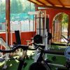 Palestra all'aperto con attrezzi da fitness sotto un tetto di legno.