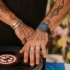 Mani tatuate su un giradischi.