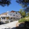 Villa su pendio, con terrazza e balaustre bianche.