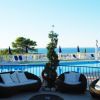 Area piscina con divanetti e vista sul mare.