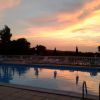 Piscina al crepuscolo con cielo colorato e riflessi.