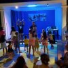 Persone ballano in un locale illuminato.