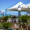 Ristorante sulla spiaggia con tavoli bianchi.