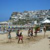Spiaggia con persone che giocano a beach volley.