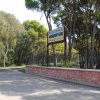 Ingresso del Residence Varantur con cartello, strada asfaltata e alberi intorno.
