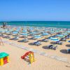 Spiaggia con ombrelloni e lettini blu e gialli.