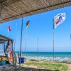 Spiaggia con bandiere e ombrelloni vicino al mare.